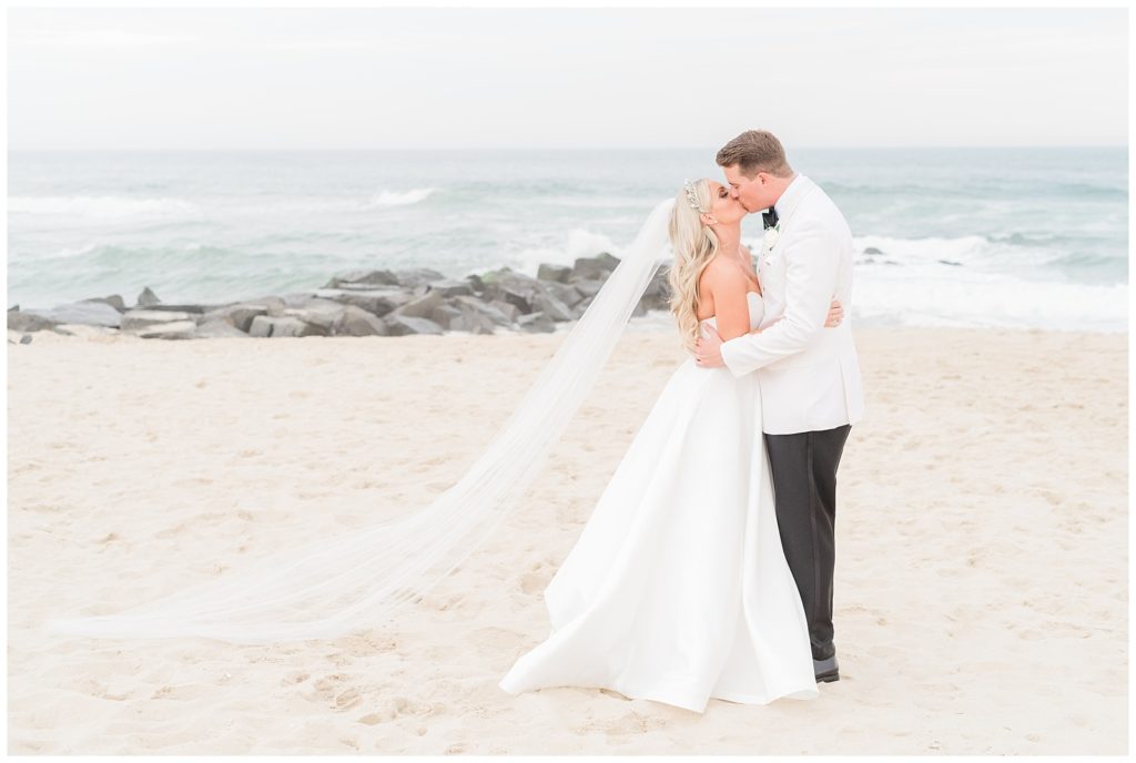 Bride and groom kiss on the beach in Spring Lake.