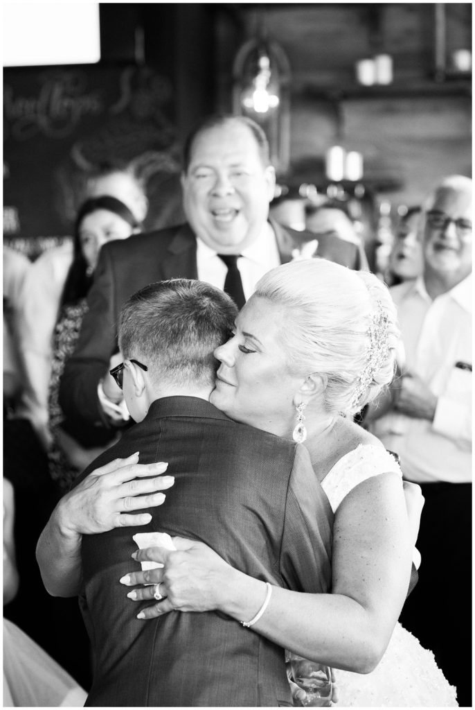 The bride hugs her son after he gives a toast.
