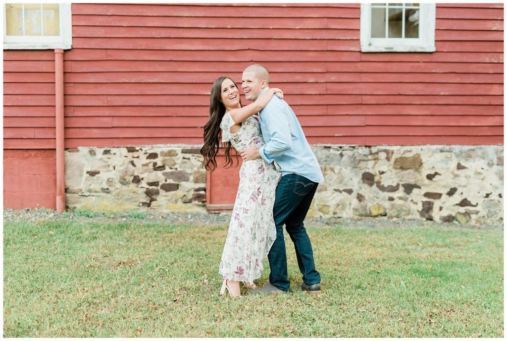 In front of a read barn, Kellie and Michael are hugging closely. 