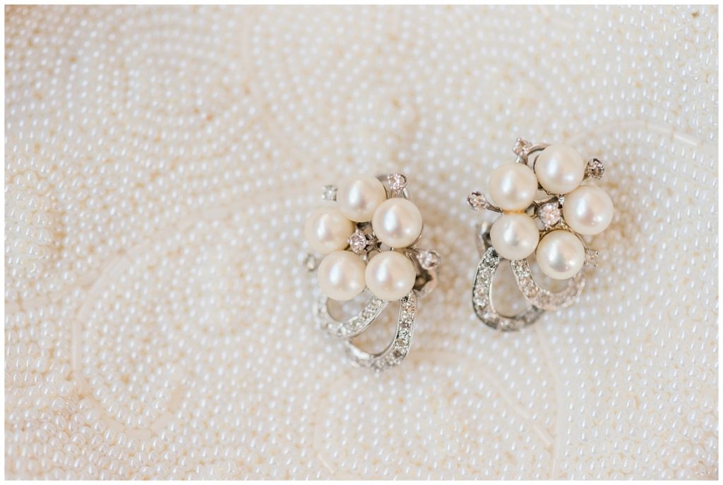two pearl earrings with 5 pearls each in a pentagon shaped design against a white background