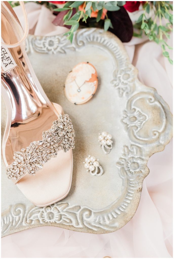 An image of Jillians shoe and earrings against a lace backgorund. There is a vintage and classy look to these items. 