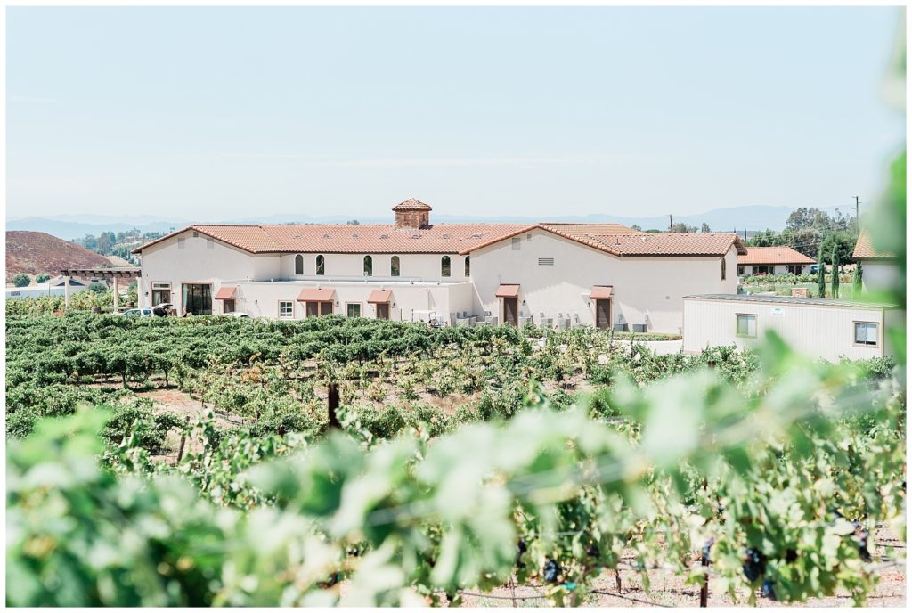 Wide exterior view of main wedding venue building sitting on a vineyard hill in Temecula, California.