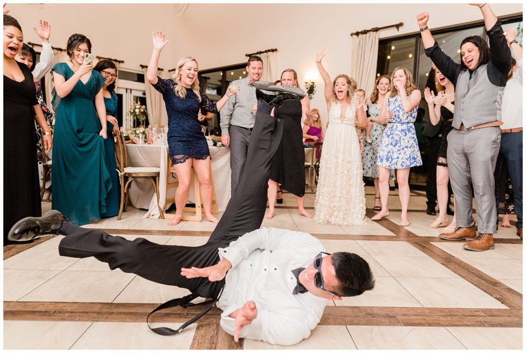 The groom breakdances on the the dancefloor during the reception at Avensole Winery wedding venue in Temecula, California.