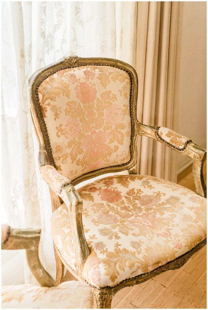 An embroidered antique arm chair in the bridal suite at Casa Romantica wedding venue in San Clemente, CA.