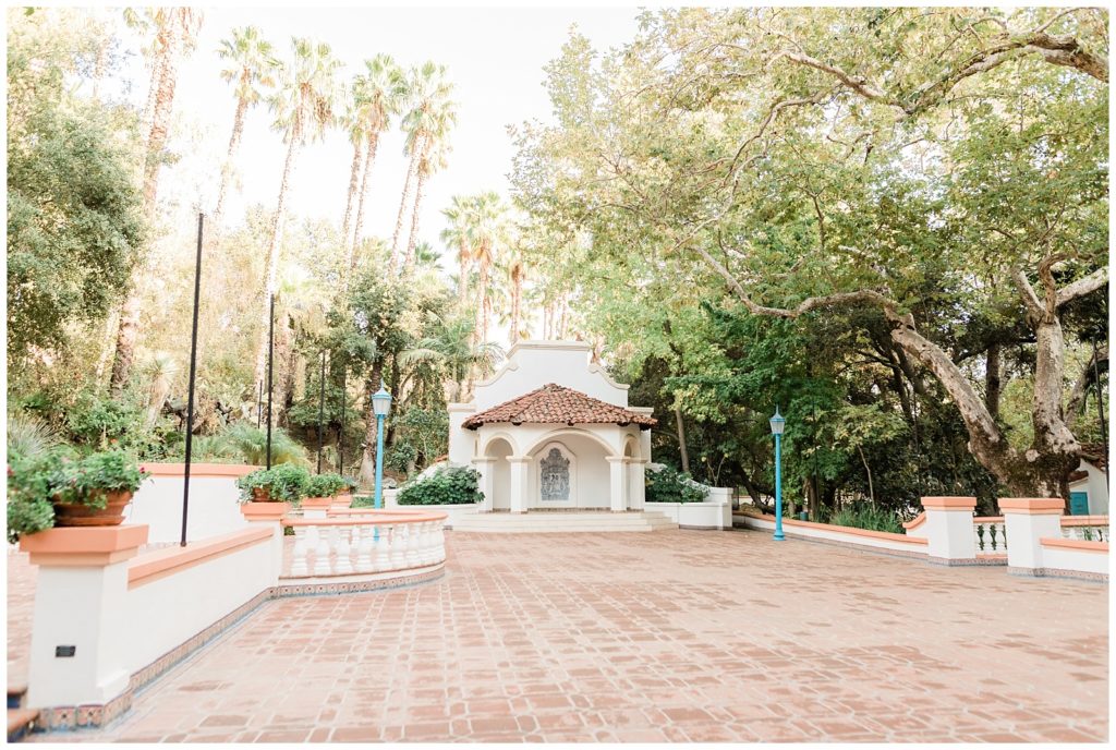 Open-air wedding venue space sits empty among tall palm and sycamore trees in Southern California.
