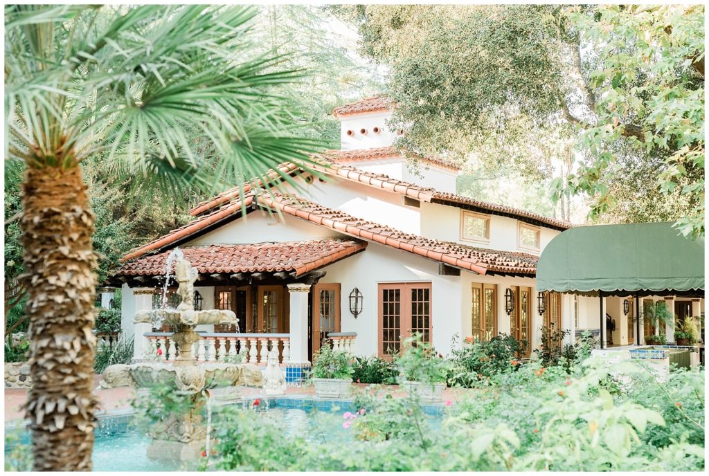 Orange County, California wedding venue overlooks a courtyard with a blue fountain and palm trees, featuring Spanish-style architecture at Rancho Las Lomas.