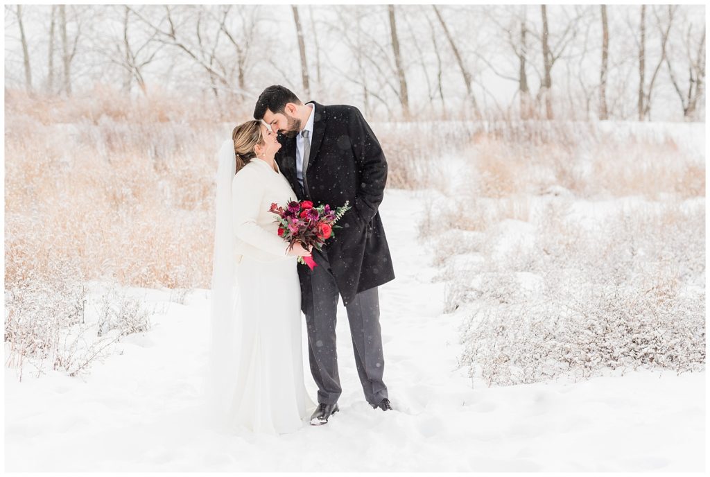 Snowy bride and groom portraits in Beacon, NY at Roundhouse Hotel winter wedding.