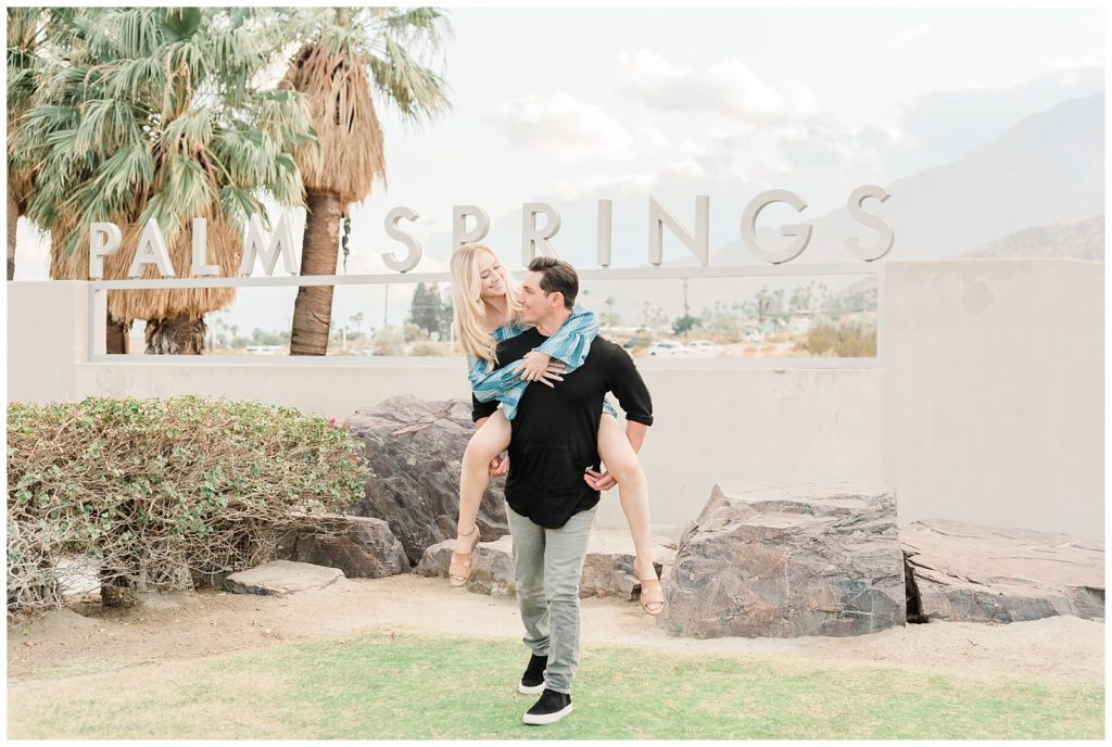 A man gives his fiancee a piggy back ride during engagement photos in Palm Springs, California.