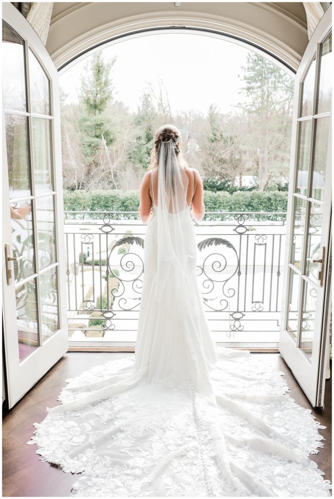 Bride in the bridal suite at Park Chateau looking out the Juliet balcony on her wedding day.